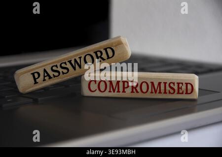Password compromised text on wooden blocks on top of a laptop. Business concept Stock Photo