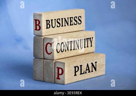 Business continuity plan text on wooden blocks with blue background. Business recovery concept Stock Photo