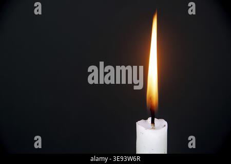 Candle light burning brightly with customizable space for text or ideas. Copy space with dark background Stock Photo