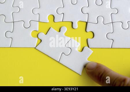 Hand placing missing jigsaw puzzles. A simple yet powerful concept of puzzle parts representing solutions unity and purposeful connection Stock Photo