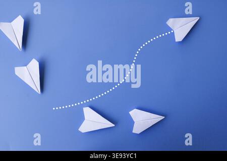 Top view of white paper airplanes with one flying at different direction Stock Photo