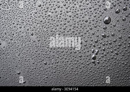 Side view of black surface with dense water droplets forming textured condensation background Stock Photo