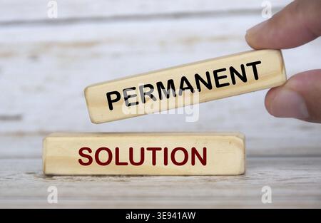 Hand holding wooden blocks with text - Permanent solution. Solution concept Stock Photo