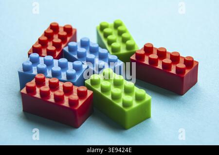 Plastic building blocks on blue background. Copy space Stock Photo