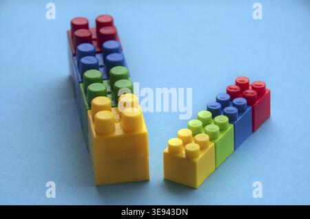 Plastic building blocks on blue background. Copy space Stock Photo