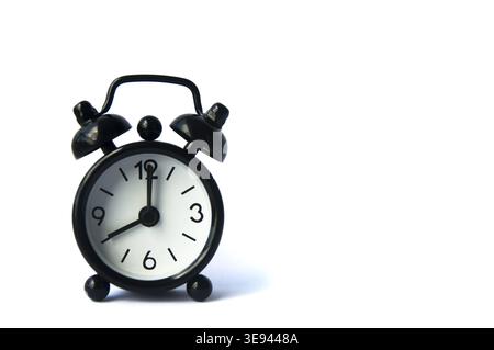 Black alarm clock isolated on white background. The clock set at 8 o'clock. Copy space Stock Photo