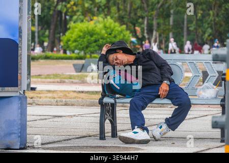 Tired Traveler Resting on a Public Seat in a Town Square Stock Photo