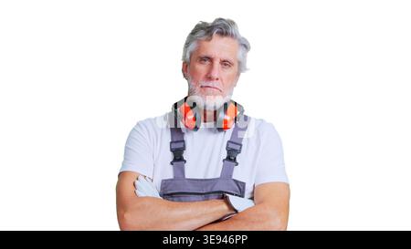 Senior construction worker standing with protective earmuffs Stock Photo