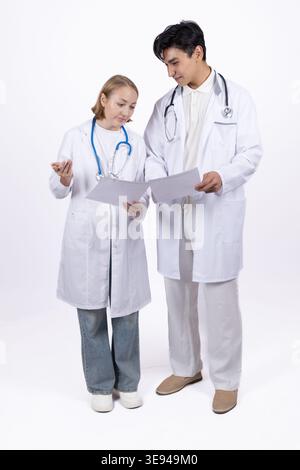Male and female doctors in white coats talking together Stock Photo