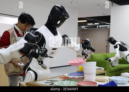 The staff train robots to perform household chores. Jiaxing,China.16th April 2026. The robots were seen conducting scenario training and data collection using flexible tactile sensors at the Industrial Embodied Intelligence Training Center of the Tsinghua Zhejiang Institute of Flexible Electronics Technology (IFET), located in Nanhu, Jiaxing City, east China’s Zhejiang Province, April 16, 2026. In the future, the center aims to promote the batch deployment of process-specific robots for autonomous work in factories and to collaborate with local partners in building robot-operated autonomous pr Stock Photo