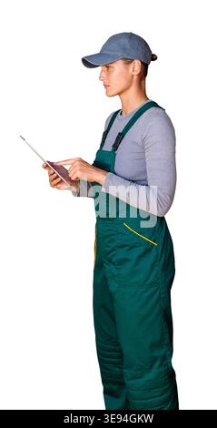 Isolated female worker in green bib overalls and cap using digital tablet. Stock Photo