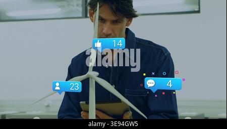 Examining wind turbine, engineer in dark button-up with tablet at bright lab showing 14 or 23 or 4 a Stock Photo