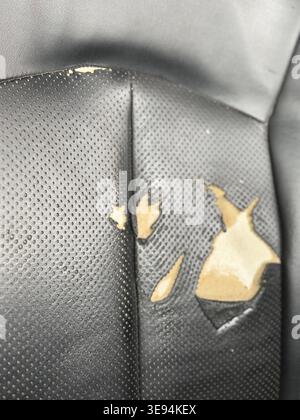 Damaged car seat upholstery with visible tears and worn material texture background. Mobile photo Stock Photo