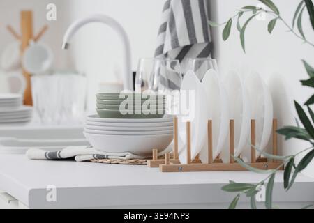 Dryer with clean dishes on counter in kitchen Stock Photo