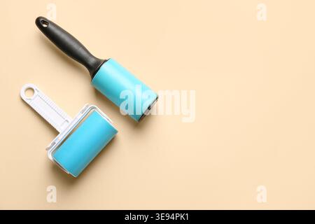 Different lint rollers on beige background Stock Photo