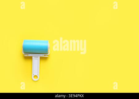 Lint roller on yellow background Stock Photo