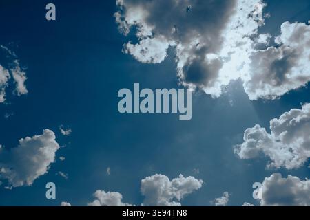 Sun light rays or beams bursting from the clouds on a blue sky. Sunbeam through the haze on blue sky. Blue sky background Stock Photo