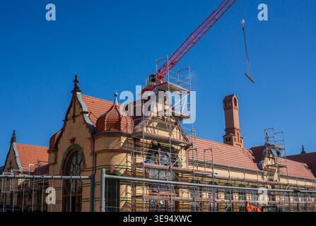 large construction site on a house with yellow crane and scaffolding, renovation in the city. Stock Photo