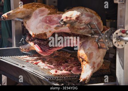 Pig placed on a barbecue, cooking slowly. Stock Photo