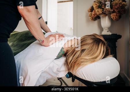 Professional therapist giving back massage to woman Stock Photo