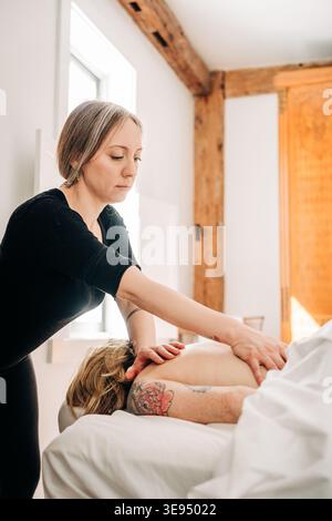 Professional therapist giving a back massage treatment Stock Photo