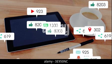 Showing black tablet displaying social alerts on wooden table, pen, coffee cup, copy space Stock Photo