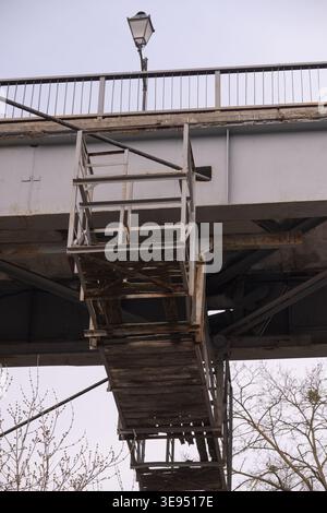 Industrial view of a weathered metal walkway on a large bridge, conveying a gritty, urban mood Stock Photo