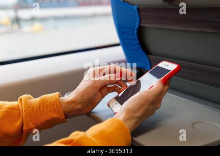Addiction of social network, internet, nomophobia concept. Female using cellphone in public transportation, texting or reading message, checking news feed, closeup. Stock Photo