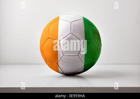 A soccer ball designed with the Ivory Coast flag, showing orange, white, and green vertical stripes on a clean white studio background. Stock Photo