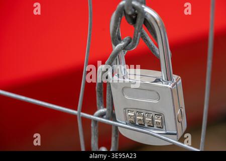 lock with code number and chain on a metal fence Stock Photo