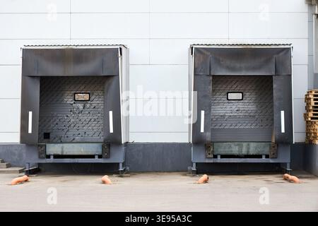 Loading dock or loading bay with bumpers, levelers, lift, dock seals or shelters, traffic lights. Loading bay is area of building where goods vehicles Stock Photo