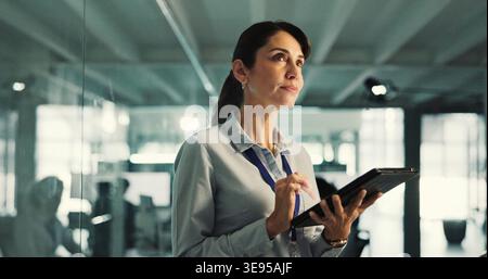 Thinking, programmer and woman with tablet in office, app development planning and software testing idea. Problem solving, tech or mature person with Stock Photo