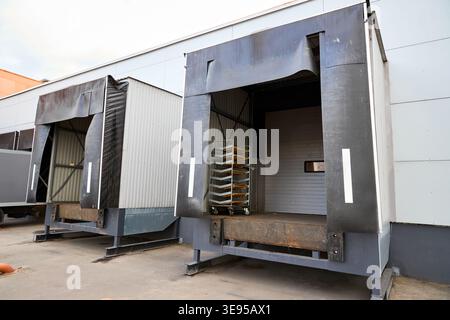 Loading dock or loading bay with bumpers, levelers, lift, dock seals or shelters, traffic lights. Loading bay is area of building where goods vehicles Stock Photo