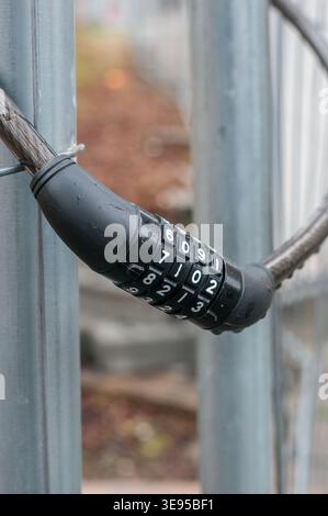 chain link fence with chain and key code padlock vertical Stock Photo