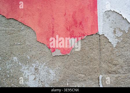 Old plaster on a house wall is weathered and chipped Stock Photo