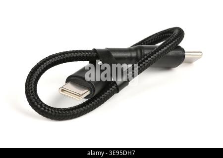 A coiled black braided USB Type-C to Type-C charging and data cable isolated on a white background. Durable nylon cord close-up. Stock Photo
