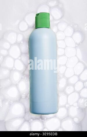 Blue Skincare Bottle with Green Cap in Foam Stock Photo