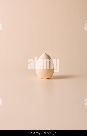 Minimal beige makeup sponge on neutral background Stock Photo