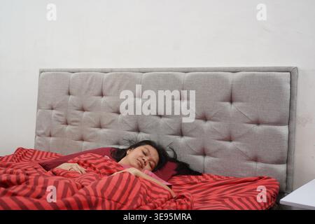Woman Sleeping Peacefully in Bed at Home Stock Photo