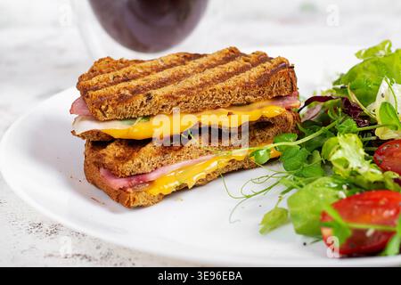 Crispy grilled sandwich with ham cheese and fresh greens Stock Photo