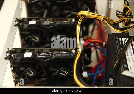Volodymyr, Ukraine - 03.11.24: graphics cards installed in a computer rig. Professional GPU mining farm for cryptocurrency with yellow and black power Stock Photo