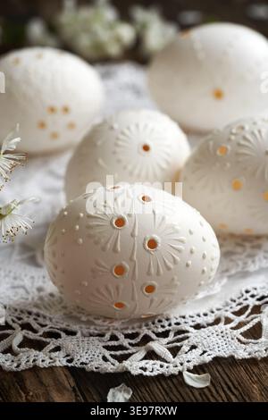 White Easter eggs decorated with wax on a wooden table Stock Photo