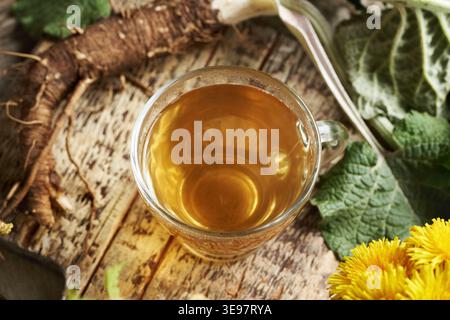 Herbal tea made of fresh burdock root on a wooden table Stock Photo