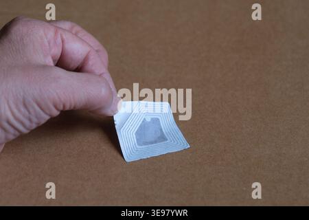 Hand sticking a rfid sticker on a box Stock Photo
