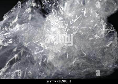 Crumpled plastic film on black background, closeup Stock Photo