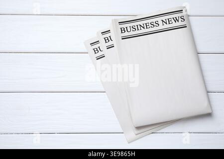 Folded newspapers on white wooden background, top view Stock Photo
