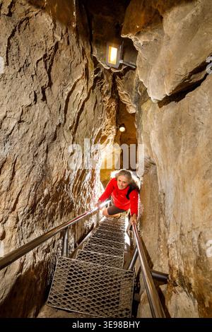 Tourist climbing stairs in Pal-Volgyi-barlang, showcave in Budapest, Hungary Stock Photo