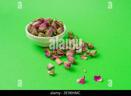 Dry Rose Buds, Roses Petals for Pink Flower Tea, Dried Persian Rosebuds, Rose Buds Textured Flowers Isolated on Green Background Stock Photo