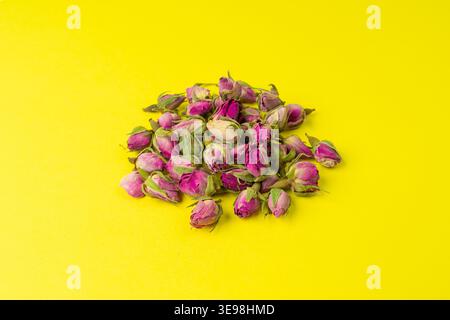 Dry Rose Buds, Roses Petals for Pink Flower Tea, Dried Persian Rosebuds, Rose Buds Textured Flowers Isolated on Yellow Background Stock Photo