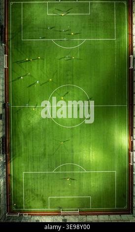 Vertical aerial photograph of a soccer field captured from directly above during a night match. The image highlights the center circle, pitch markings Stock Photo